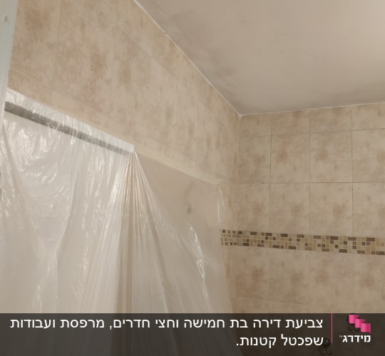 תקרה צבועה עם יריעת פלסטיק להגנה על קיר